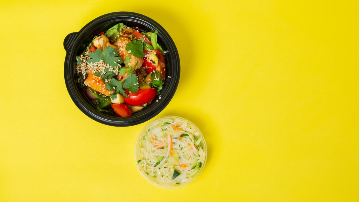 Colorful vegetable salad in a bowl with a yellow background for healthy eating concepts.